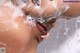 A woman is taking a shower with her tongue out.