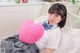 A woman laying on a bed with a pink heart shaped pillow.