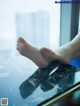 A woman's bare feet on a table in front of a window.