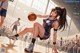 A woman in a cheerleading uniform holding a basketball on a basketball court.